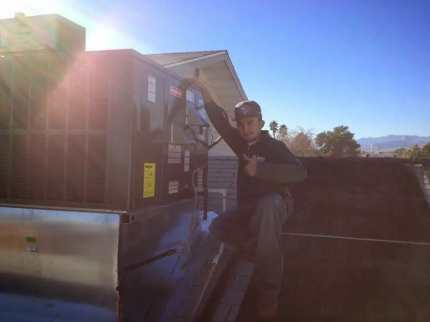 HVAC technician performing HVAC Inspection on a rooftop unit in Town 'n' Country